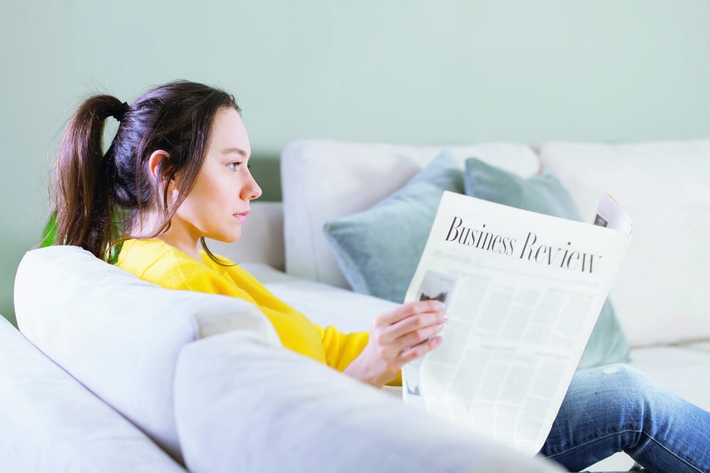 Woman reading the newspaper at home